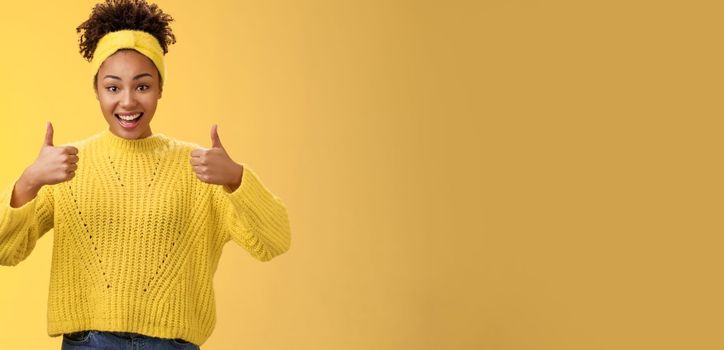 Supportive friendly modern trendy african-american female friend supporting you show thumbs-up keep up good work gesture proud doing best effort, liking result approving plan, yellow background.