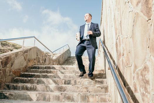 Business executive with briefcase going down the stairs.