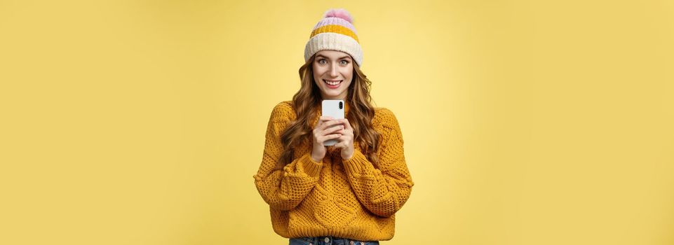 Smiling friendly-looking charming young trendy girlfriend holding brand new smartphone satisfied smiling upbeat receiving mobile phone birthday present grinning satisfied, taking photo you.