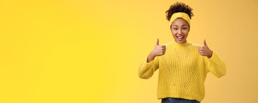Supportive friendly modern trendy african-american female friend supporting you show thumbs-up keep up good work gesture proud doing best effort, liking result approving plan, yellow background.