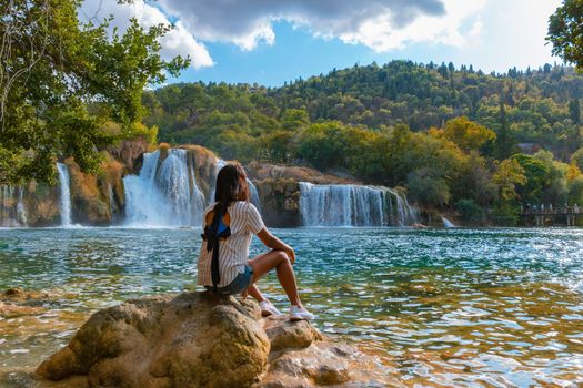 KRKA waterfalls Croatia during summer, young Asian women watch the waterfalls of krka national park Croatia on a bright summer evening in the park. 