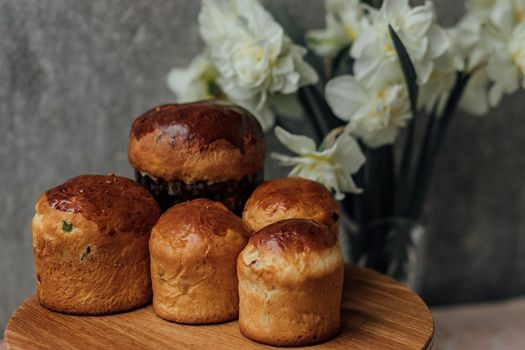 Traditional Easter bun with colored eggs and white flowers on a.