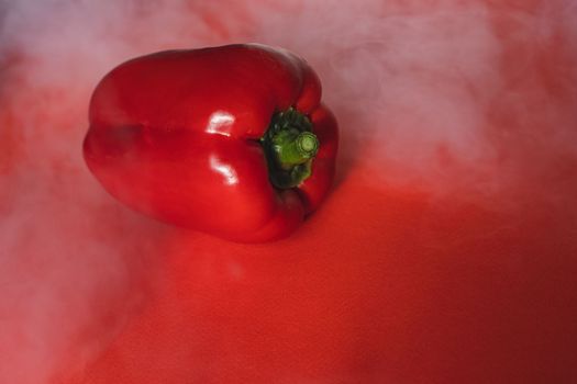 SWEET, fresh RED PEPPER ON RED BACKGROUND With smoke around, pepper. photo for the menu, proper nutrition. fresh vegetables.