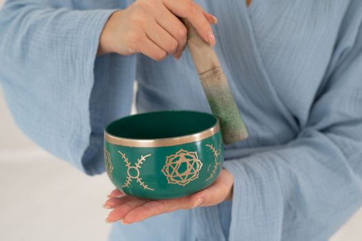 Asian woman playing Tibetan singing bowl