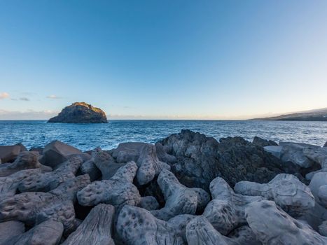 Run-down breakwater and islet in the coastline with text space