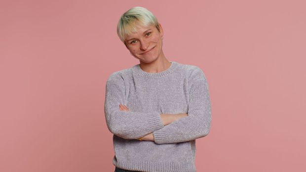 Happy calm young woman with short hair. Girl smiling friendly, glad expression looking away dreaming resting, relaxation feel satisfied concept good news. Pink background. Lgbt gay lesbian people