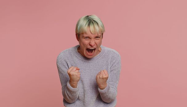 Woman with short green hair screams yell from stress tension problems feels horror hopelessness fear panic surprise shock expresses gestures rage. Girl on pink background. Lgbt gay lesbian people