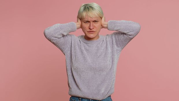 Dont want to hear and listen. Frustrated annoyed irritated woman covering ears, gesturing No, avoiding advice ignoring unpleasant noise loud voices. Girl on pink background. Lgbt gay lesbian people
