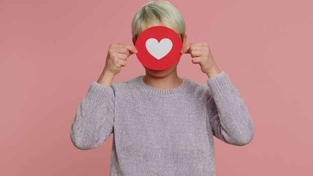 Like. Woman with short hair show heart banner inscription agrees with something, gives positive reply recommends advertisement likes good. Girl on pink studio background. Lgbt gay lesbian people