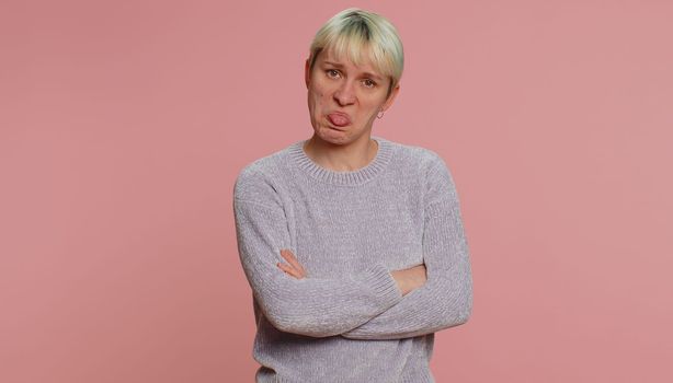 Offended millennial woman with short green hair having misunderstanding frustrated after quarrel, ignores and does not want to communicate, talk. Young girl on pink background. Lgbt gay lesbian people