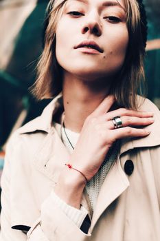 Close-up portrait Beautiful elegant woman wearing beige coat and black hat. Trendy casual outfit. Soft selective focus. grain.