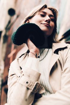 Close-up portrait Beautiful elegant woman wearing beige coat and black hat. Trendy casual outfit. Soft selective focus. grain.