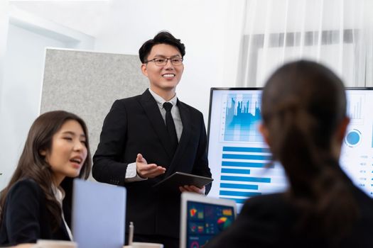 Confidence and asian businessman give presentation on financial analyzed by business intelligence in dashboard report to other people in board room meeting to promote harmony in workplace.