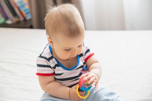 adorable baby played with a toy to develop fine motor skills.