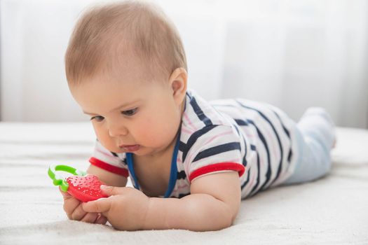 baby is nibble a rubber toy because the teeth are being cut.