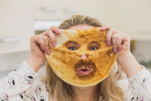 Woman in pajamas made a pancake mask.