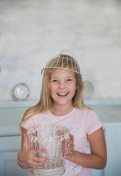 teen girl standing with a basket on her head in the kitchen.