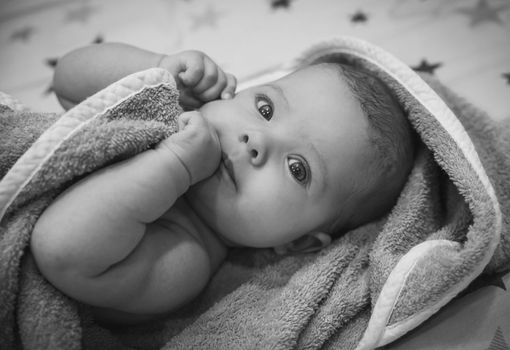 beautiful newborn baby wrapped in a towel after bathing.