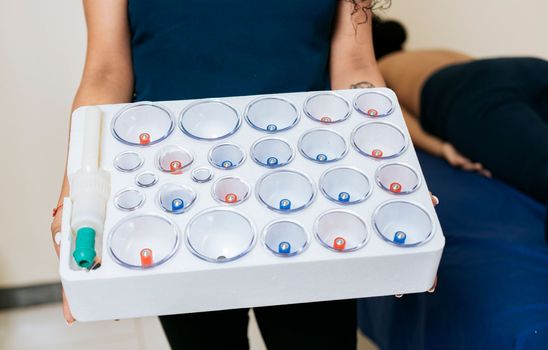 Physiotherapist hands holding cupping cups, Hands holding cupping box for physiotherapy, Cupping kit for physiotherapy