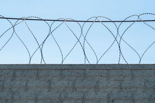 fence with barbed wire on a blue sky background. photo