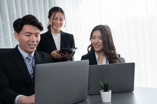 Harmony in office concept as business people analyzing dashboard paper together in workplace. Young colleagues give ideas at manager desk for discussion or strategy planning about project.