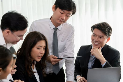 Harmony in office concept as business people analyzing dashboard paper together in workplace. Young colleagues give ideas at manager desk for discussion or strategy planning about project.