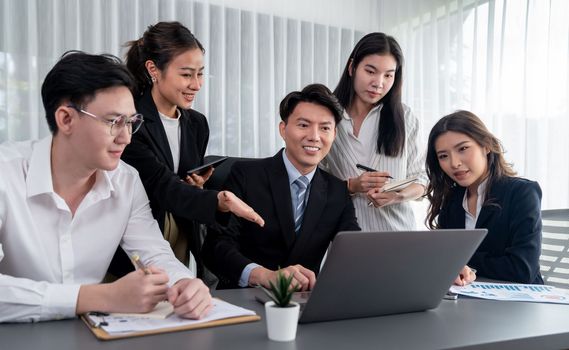 Harmony in office concept as business people analyzing dashboard paper together in workplace. Young colleagues give ideas at manager desk for discussion or strategy planning about project.