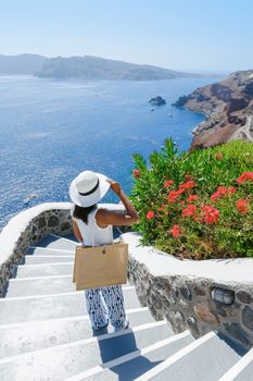 Asian woman visit Oia Santorini Greece on a sunny day during summer with whitewashed homes and churches, Greek Island Aegean Cyclades