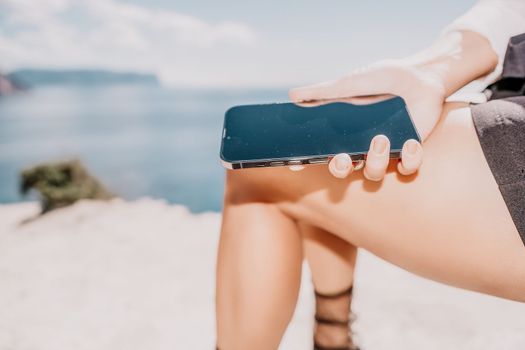 Happy girl doing yoga with laptop working at the beach. beautiful and calm business woman sitting with a laptop in a summer cafe in the lotus position meditating and relaxing. freelance girl remote work beach paradise