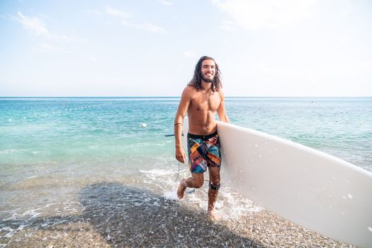 Asian man swimming in sea water and paddleboarding passing beautiful sea at summer sunset. Healthy strong male enjoy outdoor active lifestyle and water sports on holiday vacation