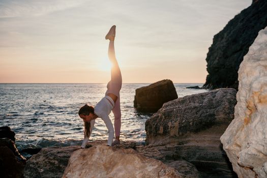 Young woman with black hair, fitness instructor in pink sports leggings and tops, doing pilates on yoga mat with magic pilates ring by the sea on the beach. Female fitness daily yoga concept