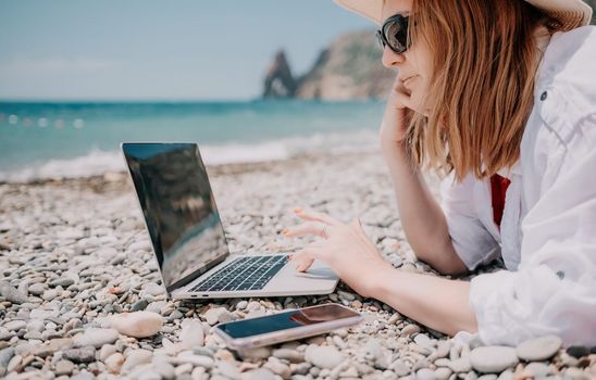 Woman sea laptop. Business woman in yellow hat working on laptop by sea. Close up on hands of pretty lady typing on computer outdoors summer day. Freelance, digital nomad, travel and holidays concept