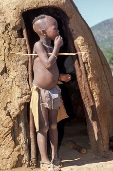 May 15, 2005. unidentified himba boy in the traditional hut, Epupa Falls, Kaokoland or Kunene Province, Namibia, Africa