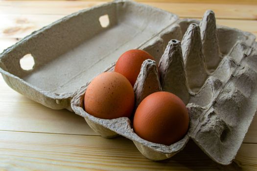 Eggs in a cardboard box. Eggs in a cardboard box on a wooden table.