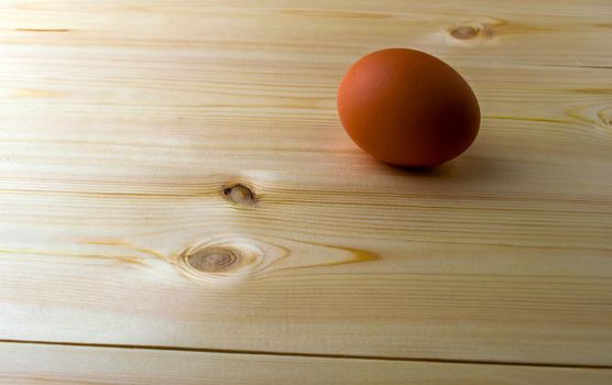 Chicken egg on a wooden table. Brown chicken egg on a wooden table.