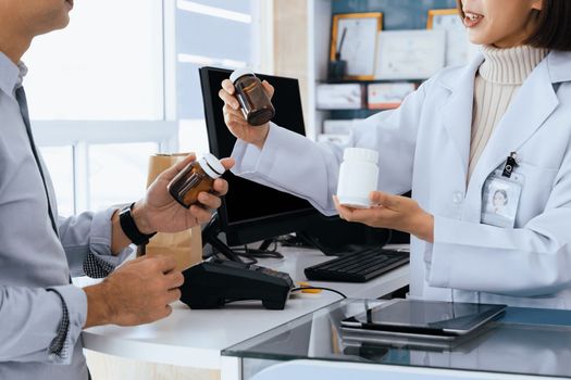 Closeup professional pharmacist advise or explain property of qualified medical product to customer in pharmacy, druggist answer to client healthcare inquiry, medical service and consultation concept.