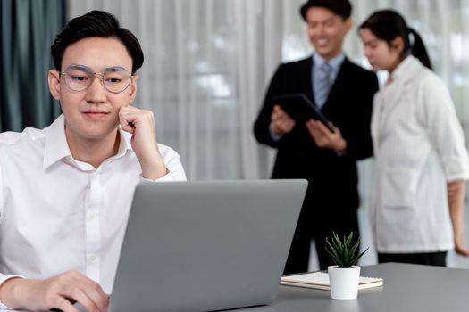 Portrait of focus young successful confident male manager, executive wearing business wear in harmony office arm crossed with blurred meeting background of colleagues, office worker.