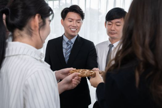 Closeup hand holding wooden gear by businesspeople wearing suit for harmony synergy in office workplace concept. Group of people hand making chain of gears into collective form for unity symbol.