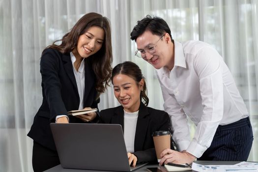 Harmony in office concept as business people analyzing dashboard paper together in workplace. Young colleagues give ideas at manager desk for discussion or strategy planning about project.