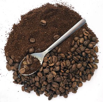 Coffee beans, ground coffee and a spoon. The photo shows coffee beans, ground coffee in the shape of a circle on a white background and a spoon.