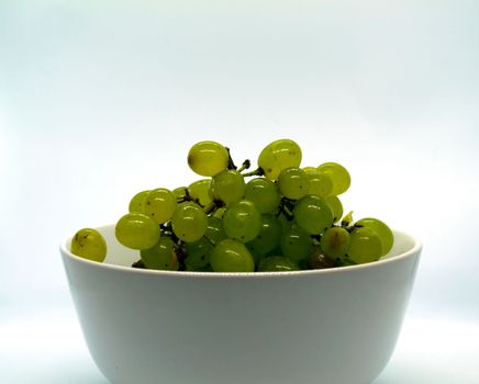 Grapes in a bowl. Green grapes in a bowl on a white background.