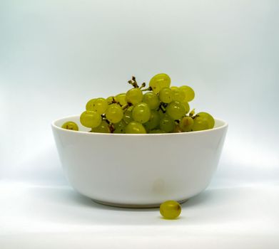 Grapes in a bowl. Green grapes in a bowl on a white background.