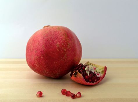 Pomegranate, photo. Photo of a pomegranate on a wooden table.