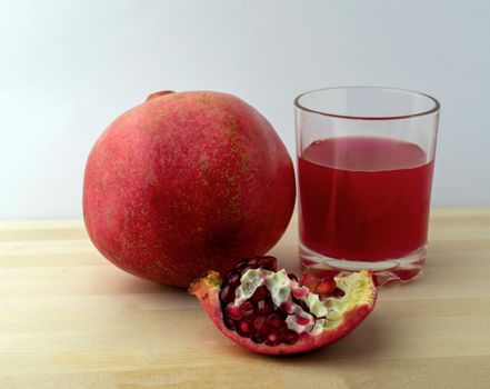 Pomegranate and pomegranate juice, photo. Photo of pomegranate and pomegranate juice on a wooden table.
