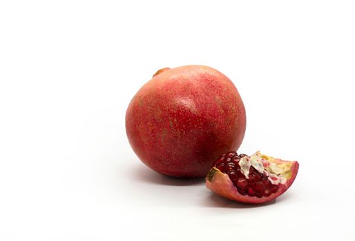 Pomegranate and pomegranate slice, photo. Pomegranate and pomegranate slice on a white background.