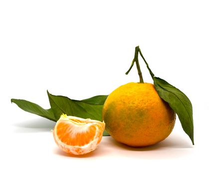 Tangerine, tangerine slice and tangerine leaves. Tangerine with leaves and a slice of tangerine on a white background, close-up.