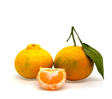 Tangerines and a slice of tangerine. Tangerines and a slice of tangerine on a white background, close-up.