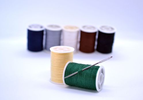 Threads and needle. In the photo, colored threads and a needle.