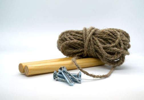 
Nails, pieces of wood and twine on a white background close-up.