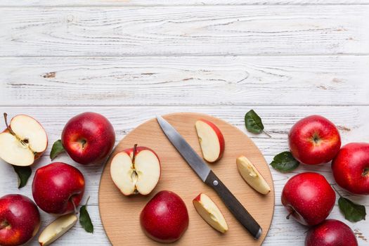 Fresh red apples with green leaves on table. cutting board with knife. Top view.